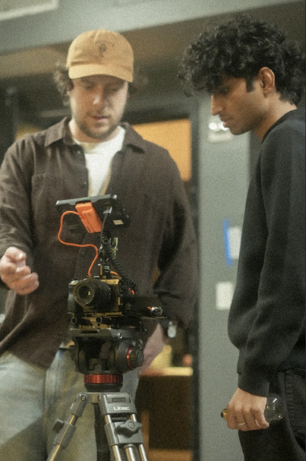Nived Krishna reviewing footage on a camera monitor with a crew member on set